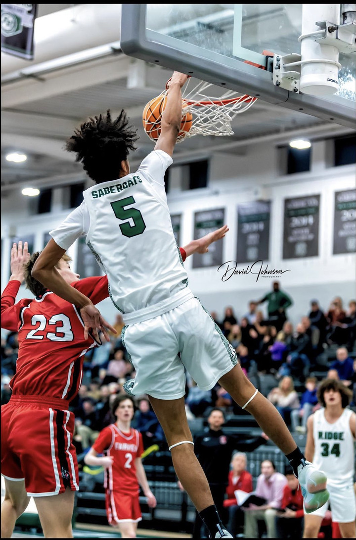 SaberCat player dunking in the Fossil Ridge gym