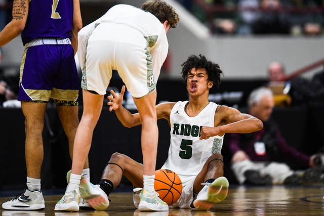 SaberCat teammates helping each other up during a game